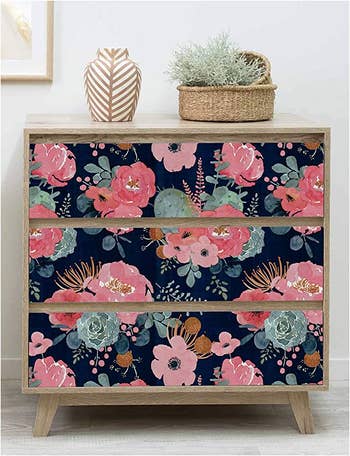 A dresser with the wallpaper covering the drawers