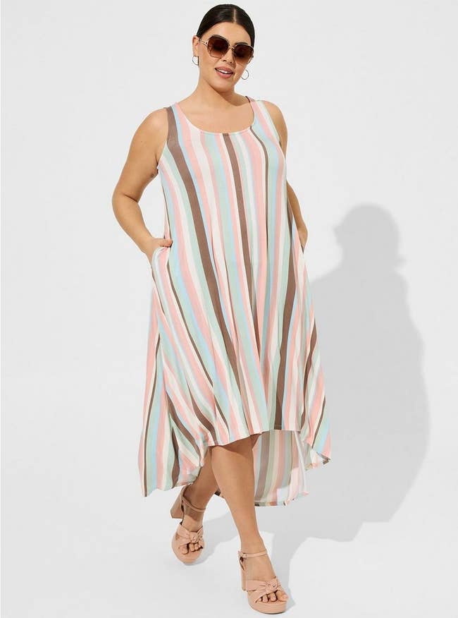 a plus size model wearing the pink, white, and brown striped hi-low dress