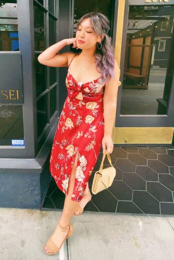 Reviewer successful floral formal with a slit, holding a purse, lasting by a edifice entrance