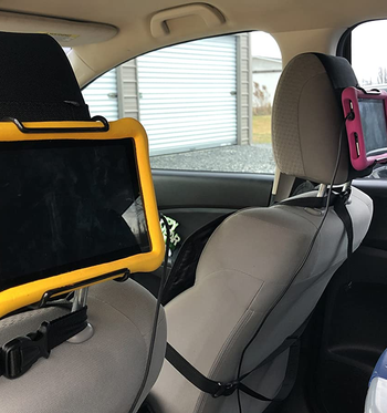 a reviewer photo of the mount on a headrest holding a tablet 
