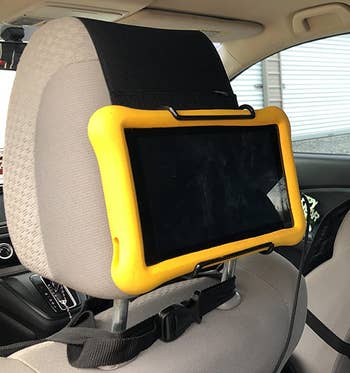 a reviewer photo of the mount on a headrest holding a tablet 