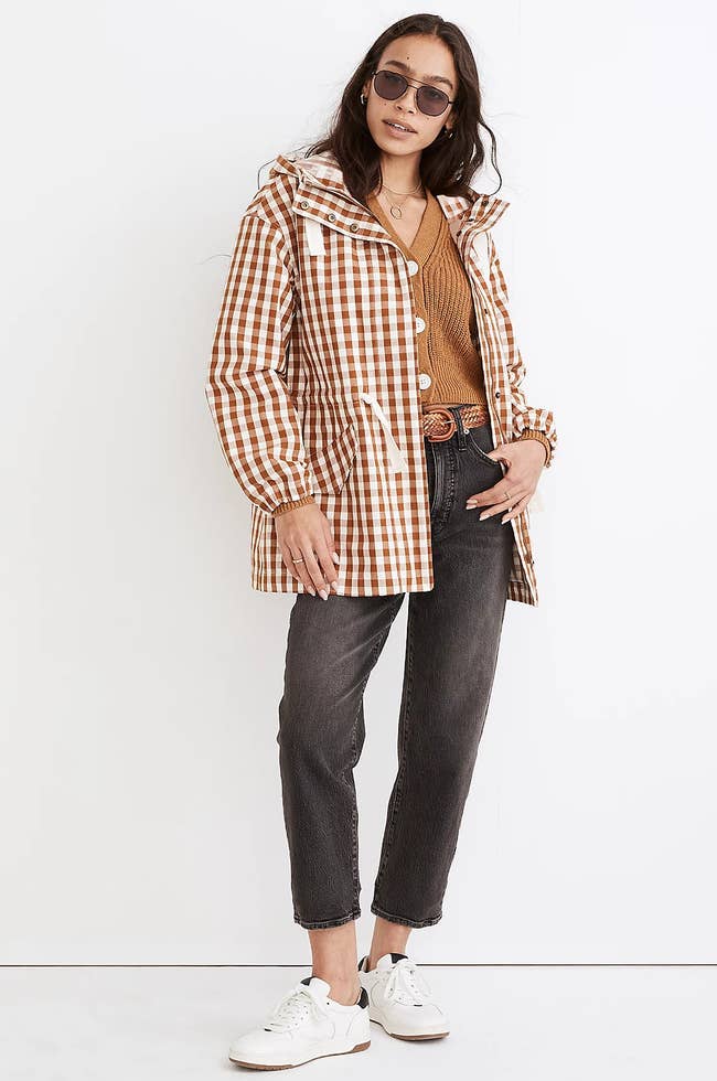 model wearing a brown gingham raincoat unzipped