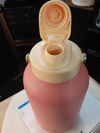 reviewer's water bottle in pink with the top flipped open