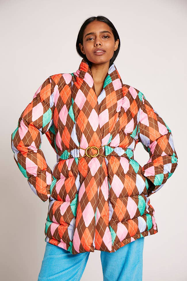 model wearing the pink, orange, and brown belted puffer coat