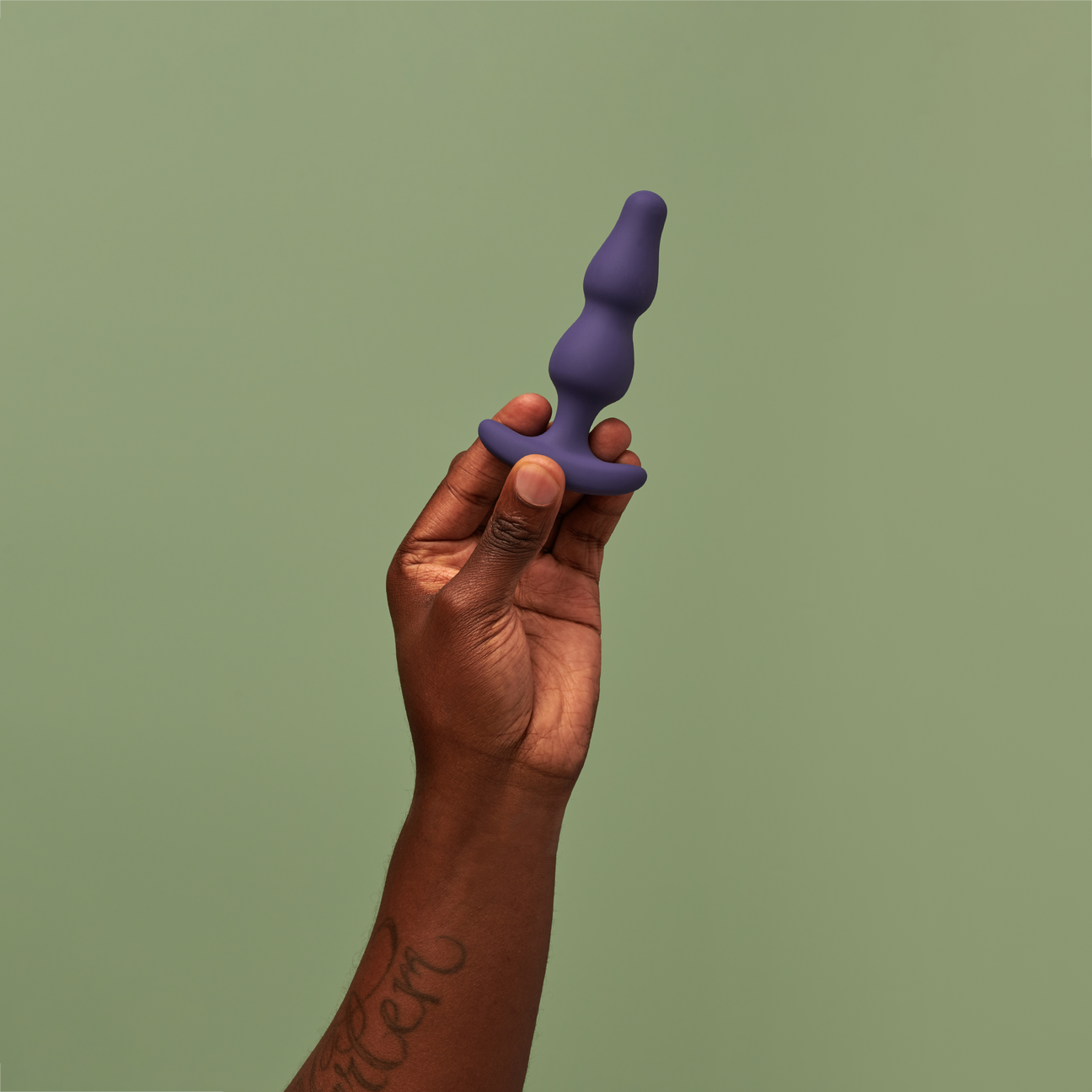 Model holding blue beaded anal plug
