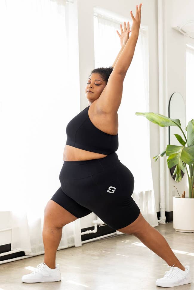 model wearing black bike shorts and doing a yoga pose