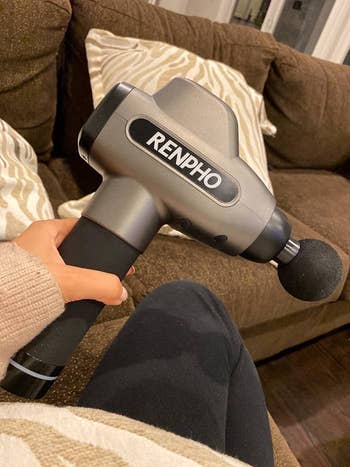 reviewer photo of the massage gun in silver