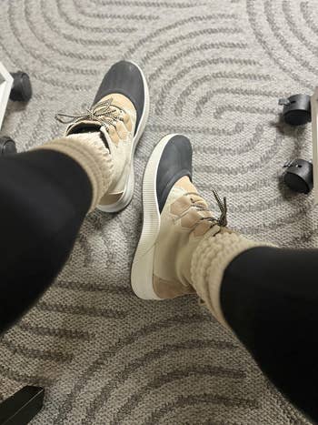 Person wearing stylish sneakers with heavy   soles and cozy socks, sitting connected  a patterned carpet adjacent   seat  wheels