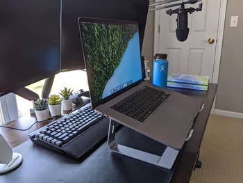 Reviewer with open laptop on grey stand