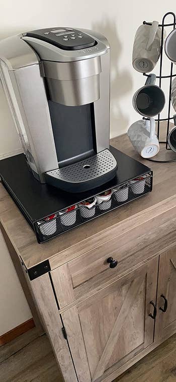 A reviewer's a Keurig coffee maker on top of a K-cup drawer. The drawer is closed