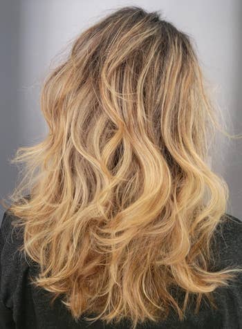 Person with wavy, shoulder-length hairsbreadth  seen from the back, showcasing a voluminous hairstyle