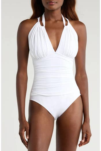 Model wearing a stylish, ruched halter-neck swimsuit