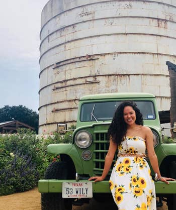 reviewer posing in front of a car wearing sunflower print outfit