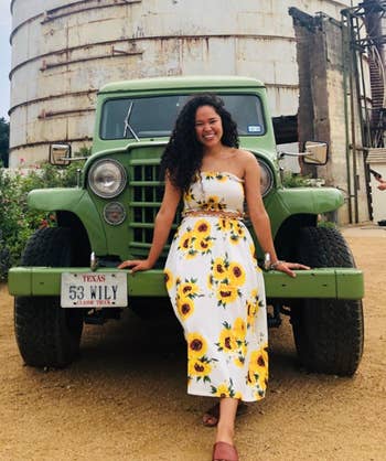 reviewer posing in front of a car wearing sunflower print outfit