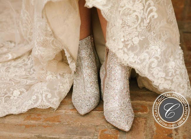 Reviewer photo of the boots covered in rhinestones peeking from underneath their wedding dress