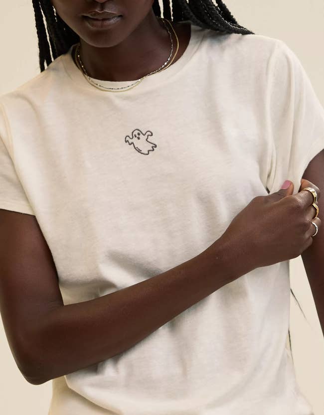 Person successful a casual t-shirt with a shade design, wearing elemental jewelry. Perfect for a laid-back, trendy look