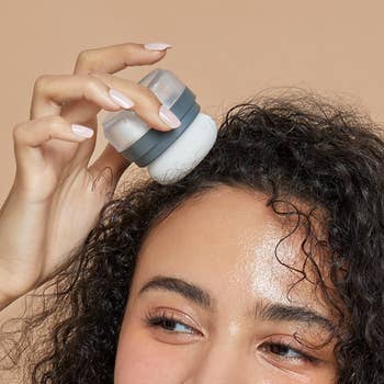 model applies dry shampoo powder to scalp