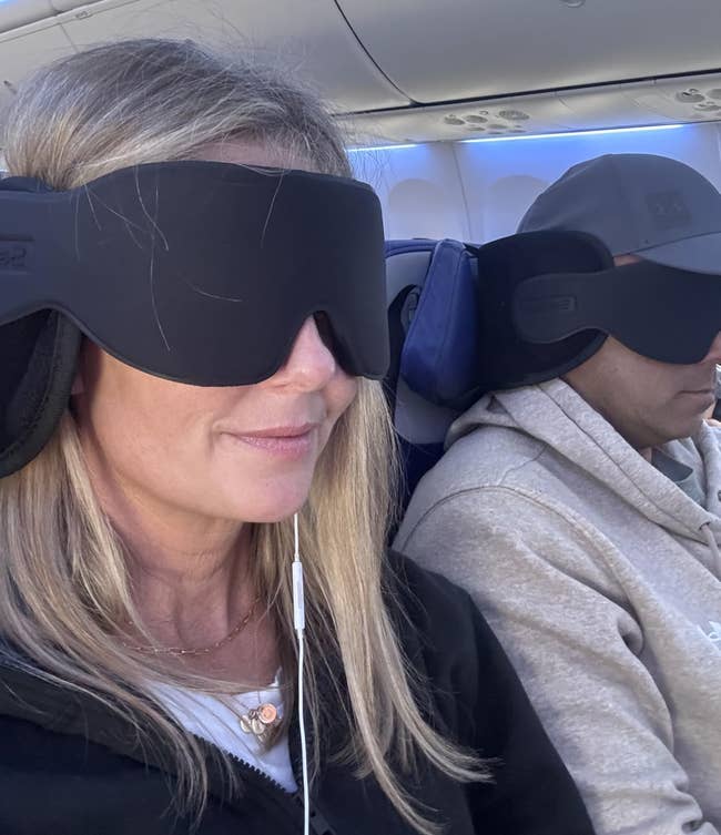 reviewers sitting in a plane using the neck pillow-eye mask