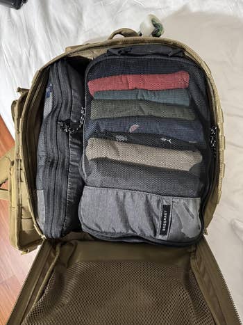 Open backpack with organized packing cubes and mesh compartments, showcasing businesslike retention for question essentials and clothing