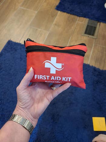 a hand holding up the first aid kit