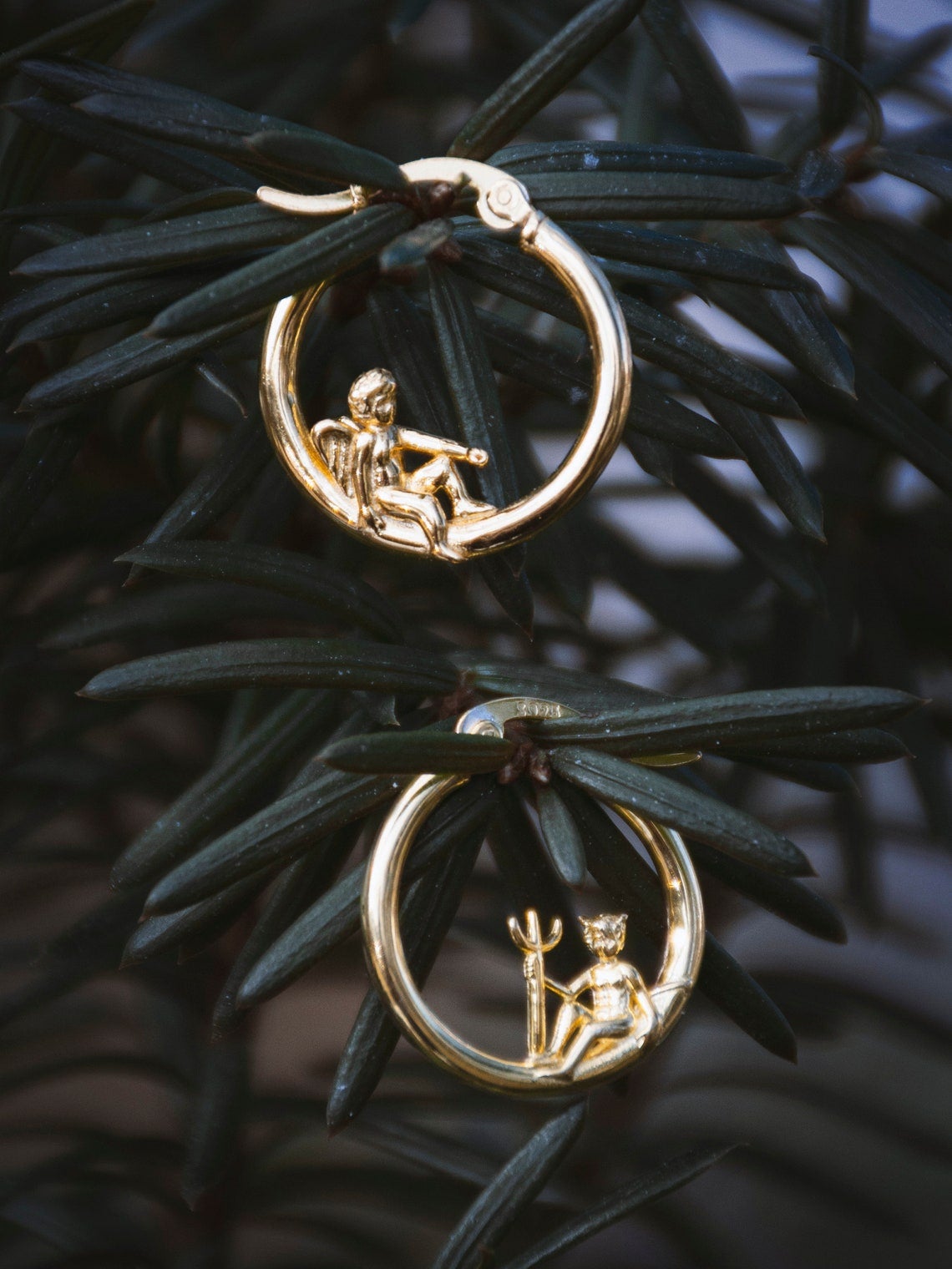 hoops with angels and devils lounging on them
