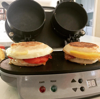 a reviewer photo of two breakfast sandwich makers being cooked with the sandwich maker