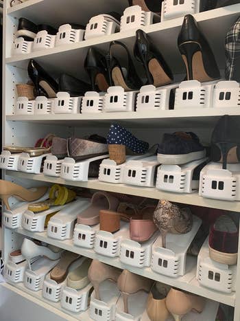 Closet with aggregate  shelves displaying assorted  women's shoes, neatly organized with footwear  stackers