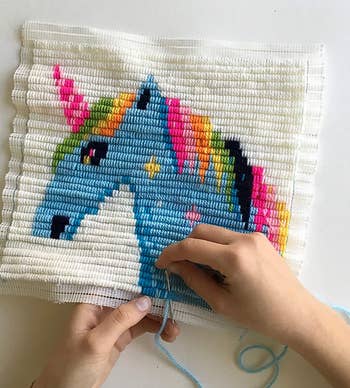 a model doing the needlepoint unicorn