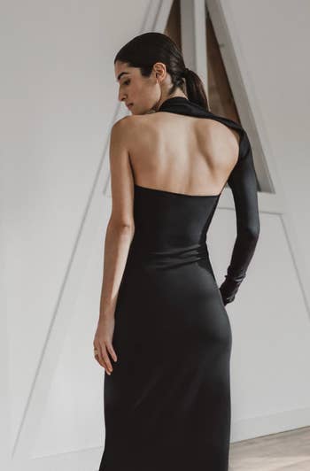 A model wearing the dress in black showing the back of the dress