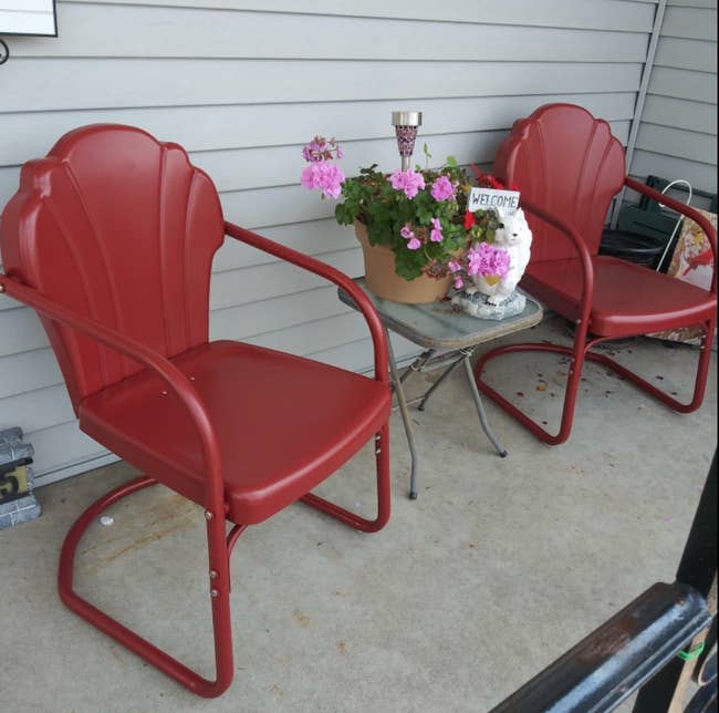 two of the tulip shaped chairs in red on a porch 