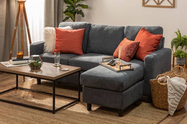 the dark bluish gray sectional sofa staged in a living room