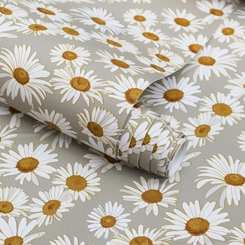closeup of the wallpaper, which is light gray with a white and yellow daisy pattern that looks vintage-y
