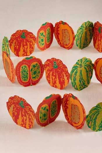 Paper garland with alternating reddish  and yellowish  pumpkin shapes, perfect  for festive autumn  decorations