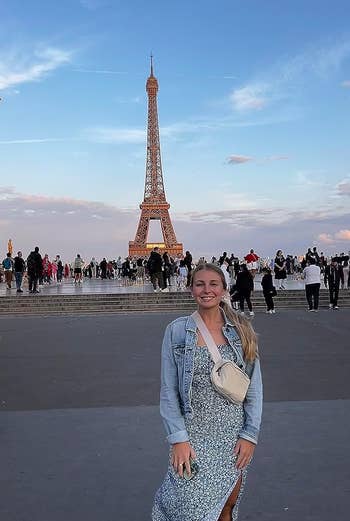 reviewer wearing the white fanny pack crossbody in front of the eiffel tower