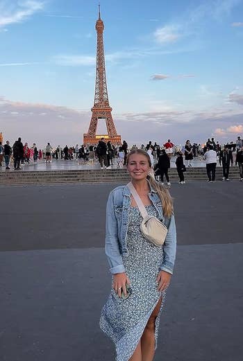 reviewer wearing the white fanny pack crossbody in front of the eiffel tower