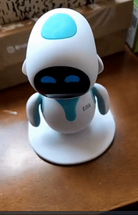 A small, white robot toy with a turquoise accent