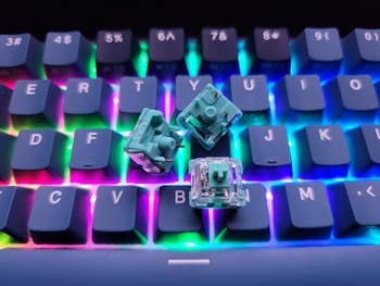 RGB-backlit keyboard with teal mechanical switches on top of the keys, showcasing customization options for gaming or typing enthusiasts