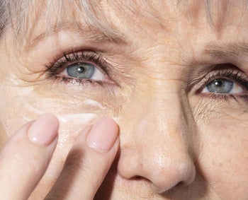 a model using eye cream under their eyes