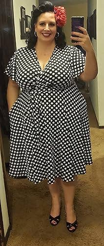Person successful  polka dot wrapper  dress, smiling successful  a reflector  selfie. They deterioration  hoop earrings and a angiosperm  hairsbreadth  accessory, showcasing a fashionable, assured  style