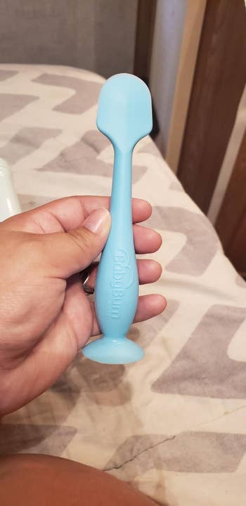 A reviewer holding the applicator in blue