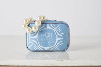 Cooling pearl bracelet successful a bluish case, labeled