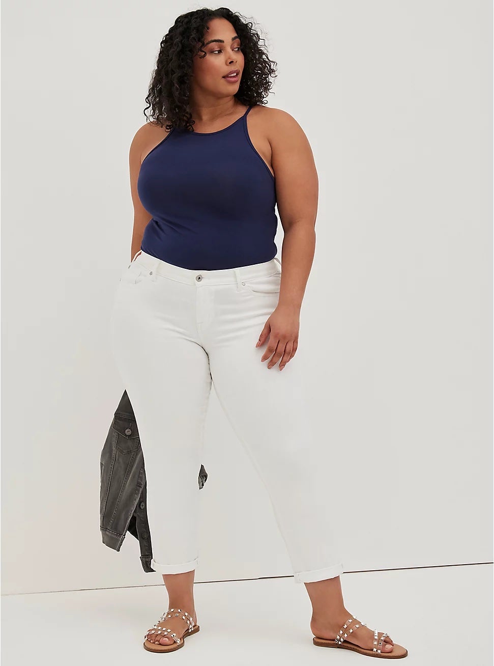 model wearing the white cuffed jeans with a navy tank and sandals