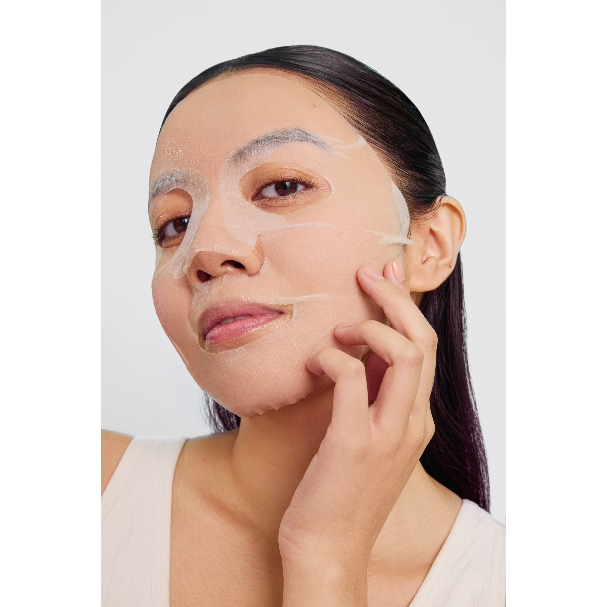 Person applying a expanse  disguise  connected  their face, mildly  pressing it onto their skin