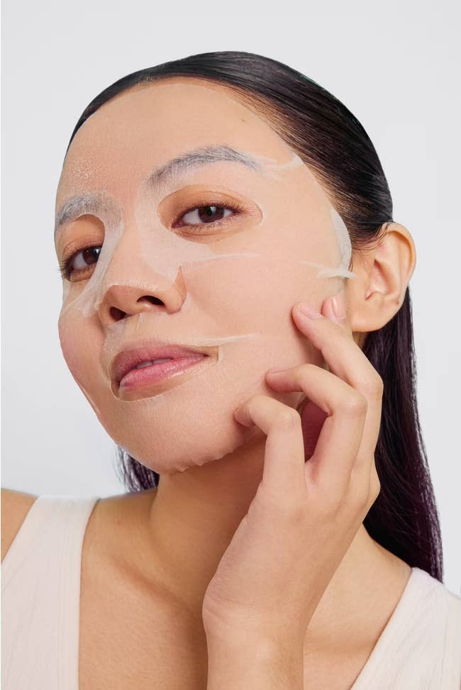Person applying a expanse disguise connected their face, mildly pressing it onto their skin