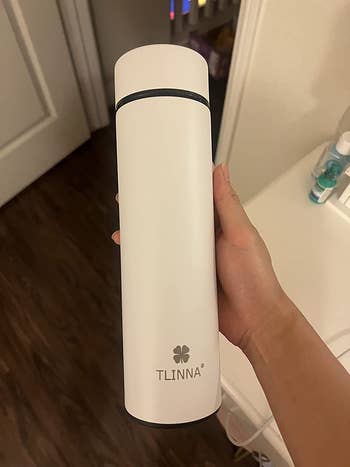 reviewer holding white twist top lid bottle 
