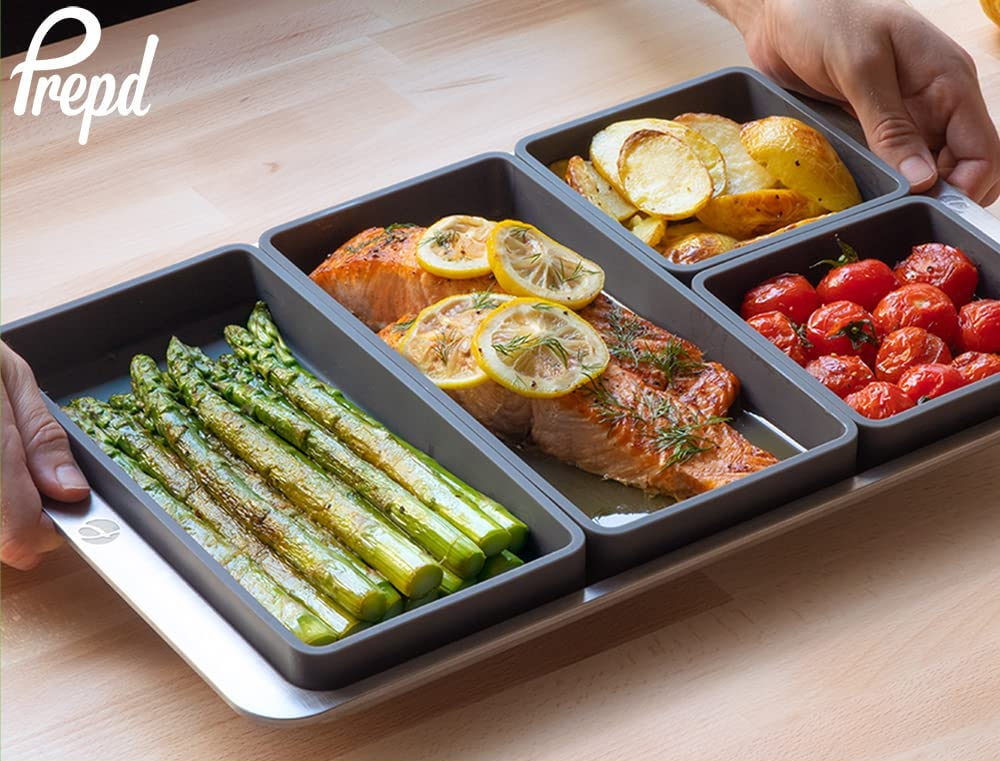 the gray dividers holding salmon and veggies on a baking sheet
