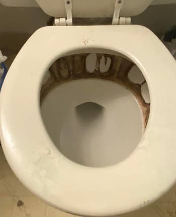 Toilet with disposable   rust and mineral stains astir   the vessel  nether  the seat