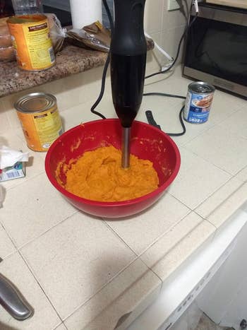 A reviewer's black blender in a red bowl full of pumpkin puree