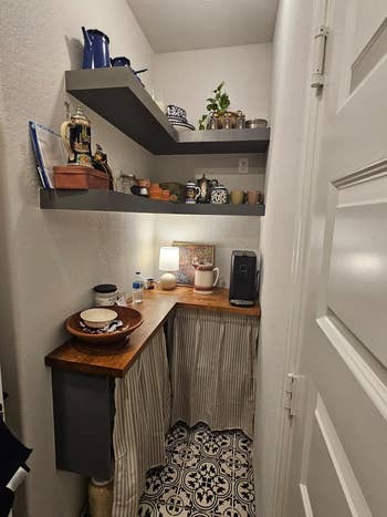 Small pantry nook with woody  countertop and striped curtains conceal little   storage