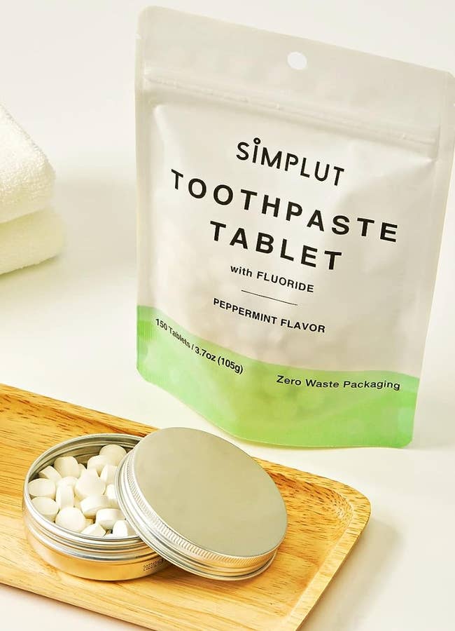 White tablets inside of a metal tin on a bathroom counter 